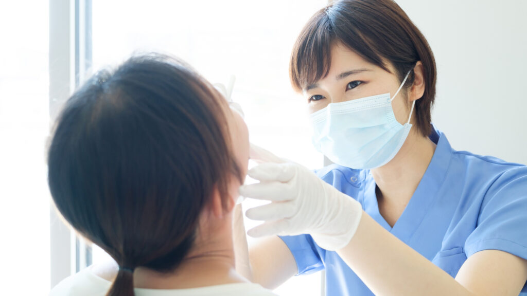 女性患者の口内を確認する女性歯科衛生士